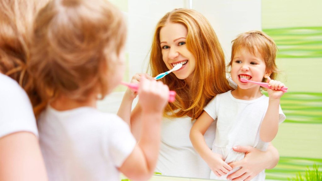 parent as a rolemodel showing her toddler how important it is to brush teeth every day twice